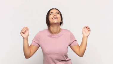 Güzel genç bir kadın son derece mutlu ve şaşırmış görünüyor, başarıyı kutluyor, bağırıyor ve zıplıyor.