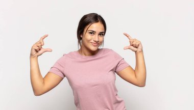 Güzel, genç bir kadın kendi gülüşünü çiziyor, iki eliyle, olumlu ve mutlu görünüyor, sağIık kavramı