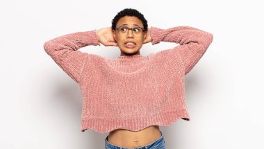 Genç afro kadın kendini stresli, endişeli, endişeli ya da korkmuş hissediyordu. Elleri başının üstünde, hatayla panikliyordu.