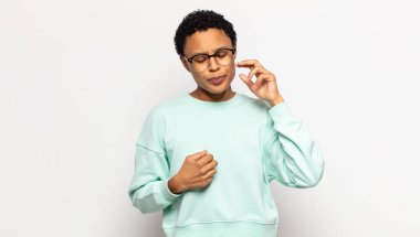 Genç afro kadın stresli, hayal kırıklığına uğramış ve yorgun hissediyordu. Endişeli ve sorunlu bir bakışla boynunu ovuyordu.