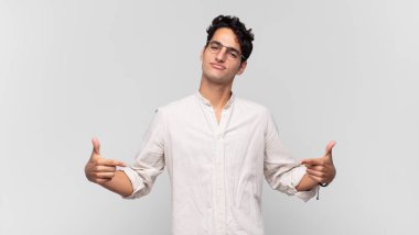 Genç yakışıklı adam gururlu, kibirli, mutlu, şaşırmış ve tatmin olmuş görünüyor, kendini gösteriyor, kazanan gibi hissediyor.