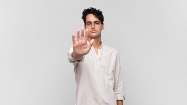 Genç ve yakışıklı adam ciddi, sert, hoşnutsuz ve kızgın görünüyor.