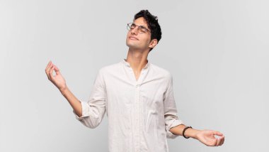 Genç yakışıklı adam gülümsüyor, kaygısız hissediyor, rahat ve mutlu, dans ediyor ve müzik dinliyor, bir partide eğleniyor.