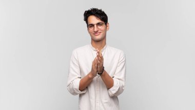 Genç yakışıklı adam kendini mutlu ve başarılı hissediyor, gülümsüyor ve alkışlıyor, alkışlarla tebrik ediyor.