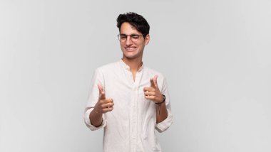 Genç yakışıklı adam kendini mutlu, havalı, tatmin olmuş, rahat ve başarılı hissediyor, kameraya bakıyor, seni seçiyor.