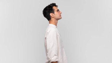 Profil görünümündeki genç yakışıklı adam ilerideki boşluğu kopyalamaya çalışıyor, düşünüyor, hayal ediyor ya da hayal kuruyor.