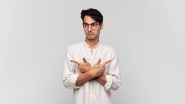 Şaşkın, kafası karışmış, güvensiz ve şüpheyle zıt yönlere bakan genç yakışıklı bir adam.