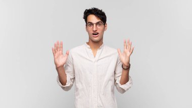 Genç yakışıklı adam şok olmuş ve şaşkın bakıyor, inanılmaz bir şey fark ettiğinde çenesi şaşkın şaşkın