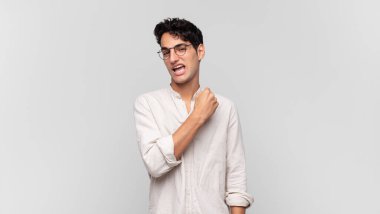 Genç yakışıklı adam mutlu, pozitif ve başarılı hissediyor, bir meydan okumayla karşılaştığında motive oluyor veya iyi sonuçları kutluyor.