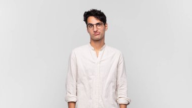 Genç yakışıklı, kafası karışık ve şüpheli hissediyor, merak ediyor ya da karar vermeye çalışıyor.