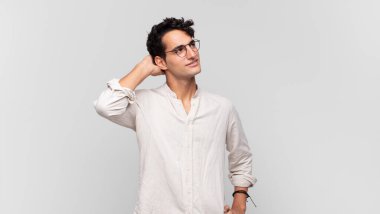 Genç yakışıklı adam neşeyle ve tesadüfen gülümsüyor, olumlu, mutlu ve kendinden emin bir bakışla göğüs göğüse.