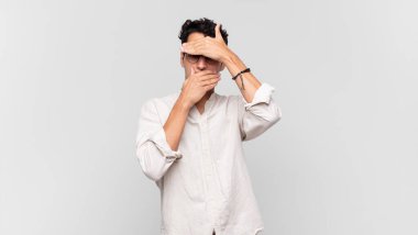 Genç yakışıklı adam kameraya hayır diyen iki eliyle yüzünü kapatıyor! Resimler reddediliyor ya da yasaklanıyor