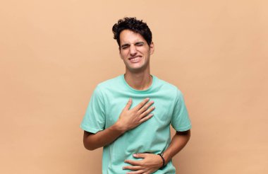 Genç yakışıklı adam komik bir şakaya yüksek sesle gülüyor, mutlu ve neşeli hissediyor, eğleniyor.