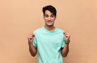 Genç yakışıklı adam şok olmuş, heyecanlı ve mutlu, gülüyor ve başarıyı kutluyor, vay canına diyor.!