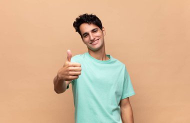 Genç yakışıklı, gururlu, tasasız, kendinden emin ve mutlu, başparmaklarıyla gülümseyen.