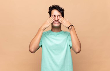 Genç yakışıklı adam gülümsüyor ve mutlu hissediyor, iki eliyle gözlerini kapatıyor ve inanılmaz bir sürpriz bekliyor.