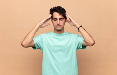 Genç yakışıklı adam konsantre, düşünceli ve ilham verici, beyin fırtınası yapıyor ve hayal kuruyor.