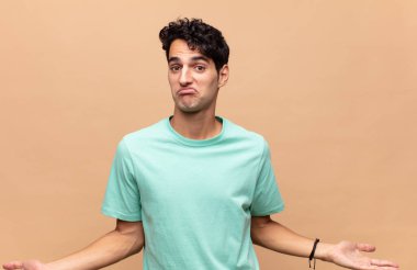 Genç yakışıklı bir adam bilgisiz ve kafası karışık, hiçbir fikri yok, aptal ya da aptal bir bakışla tamamen kafası karışmış.