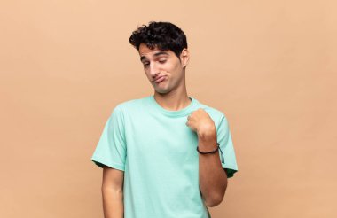Genç yakışıklı adam kibirli, başarılı, pozitif ve gururlu görünüyor, kendini gösteriyor.