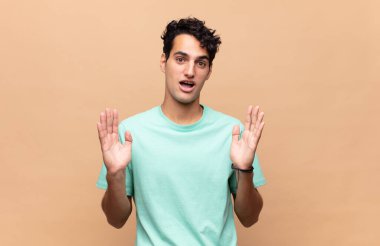 Genç yakışıklı adam şok olmuş ve şaşkın bakıyor, inanılmaz bir şey fark ettiğinde çenesi şaşkın şaşkın