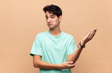 Genç yakışıklı bir adam kafası karışık ve bilgisiz, şüpheli bir açıklama ya da düşünceyi merak ediyor.