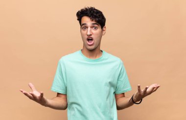 Genç, yakışıklı, ağzı açık ve şaşkın, şok olmuş ve şaşırmış bir adam.