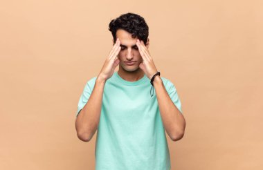 Genç ve yakışıklı bir adam stresli ve hayal kırıklığına uğramış görünüyor. Baskı altında çalışıyor ve sorunları var.