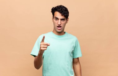 Genç yakışıklı bir adam kızgın agresif bir ifadeyle kameraya bakıyor. Öfkeli, çılgın bir patron gibi görünüyor.