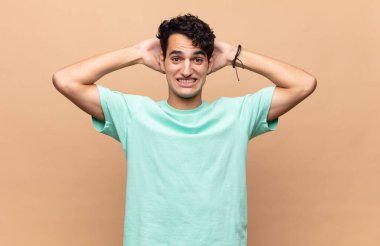 Genç yakışıklı adam mutlu, kaygısız, arkadaş canlısı ve rahat görünüyor. Hayattan ve başarıdan keyif alıyor, olumlu bir tavırla.