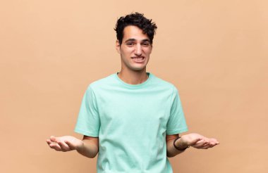 Genç yakışıklı bir adam bilgisiz ve kafası karışık, hangi seçeneği seçeceğinden emin değil, merak ediyor.