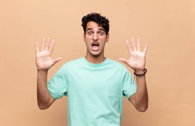 Genç yakışıklı adam sersemlemiş ve korkmuş hissediyor. Korkutucu bir şeyden korkuyor. Elleri açık ve uzak dur diyor.