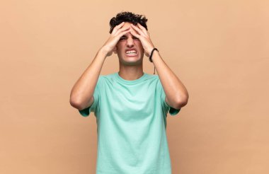 Genç yakışıklı adam el ele tutuşuyor, ağzı açık, son derece şanslı, şaşırmış, heyecanlı ve mutlu hissediyor.