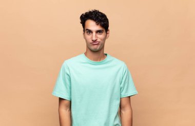 Genç yakışıklı, kafası karışık ve şüpheli hissediyor, merak ediyor ya da karar vermeye çalışıyor.