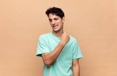 Genç yakışıklı adam mutlu, pozitif ve başarılı hissediyor, bir meydan okumayla karşılaştığında motive oluyor veya iyi sonuçları kutluyor.