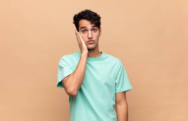 Genç yakışıklı adam şok olmuş ve ağzı açık halde yüz yüze inanamamaktan şaşkına dönmüş durumda.