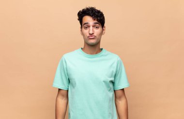 Genç yakışıklı adam dudaklarını birbirine bastırıyor, tatlı, eğlenceli, mutlu, sevimli bir yüz ifadesiyle, öpücük yolluyor.