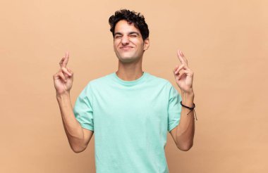 Genç yakışıklı adam gergin ve umutlu, şans diliyor ve dua ediyor.