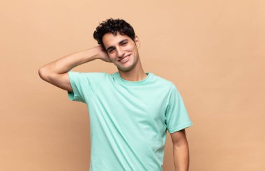 Genç yakışıklı adam neşeyle ve tesadüfen gülümsüyor, olumlu, mutlu ve kendinden emin bir bakışla göğüs göğüse.