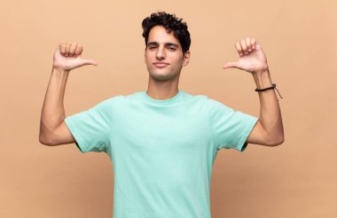 Genç yakışıklı adam gururlu, kibirli ve kendinden emin, tatmin olmuş ve başarılı görünüyor, kendini işaret ediyor.