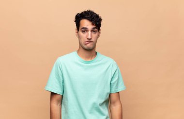 Genç yakışıklı adam kendini cahil, kafası karışmış ve hangi seçeneği seçeceği konusunda kararsız hissediyor, sorunu çözmeye çalışıyor.