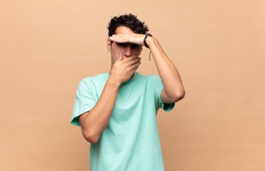 Genç yakışıklı adam kameraya hayır diyen iki eliyle yüzünü kapatıyor! Resimler reddediliyor ya da yasaklanıyor