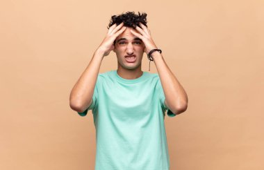 Dehşete kapılmış ve şok olmuş hisseden genç yakışıklı adam, bir hata yüzünden el ele tutuşuyor ve panikliyor.