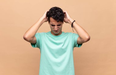 Genç ve yakışıklı bir adam stresli ve hayal kırıklığına uğramış hissediyor. Yumruk yumruğa, yorgun, mutsuz ve migren ağrısı çekiyor.