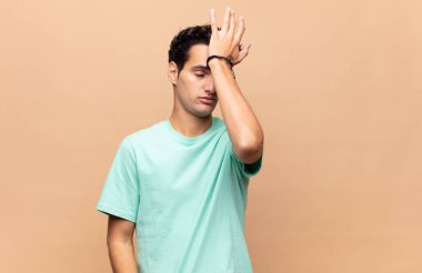 Aptal bir hata yaptıktan ya da hatırladıktan sonra kendini aptal gibi hissederek avuçtan avuca kadar büyüten genç yakışıklı adam.