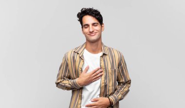 Genç yakışıklı adam komik bir şakaya yüksek sesle gülüyor, mutlu ve neşeli hissediyor, eğleniyor.