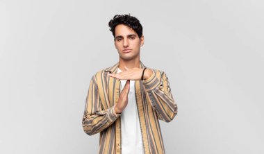 Genç yakışıklı adam ciddi, sert, kızgın ve canı sıkkın görünüyor.