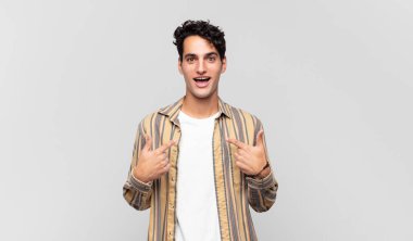 Genç yakışıklı adam mutlu, şaşkın ve gururlu, heyecanlı, şaşkın bakışlarıyla kendini işaret ediyor.