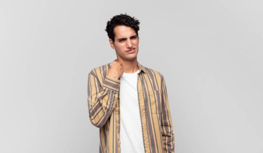 Genç ve yakışıklı bir adam stresli, endişeli, yorgun ve hayal kırıklığına uğramış, gömleğini çekiştirmiş, sorunlu görünüyor.