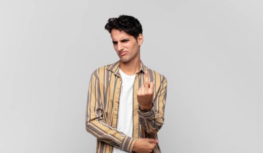 Genç, yakışıklı bir adam kızgın, sinirli, asi ve agresif orta parmağını sallayarak karşılık veriyor.