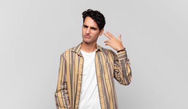 Genç yakışıklı, kafası karışmış ve kafası karışmış hissediyor. Deli, deli ya da aklını kaçırmış olduğunu gösteriyor.